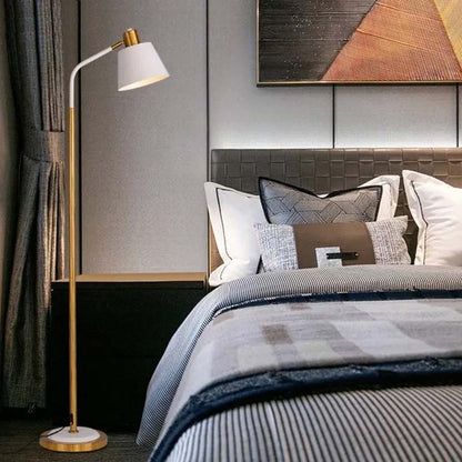 A white floor lamp in a bright bedroom next to the bed