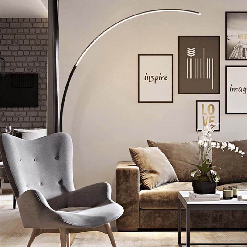 Arc floor lamp in a living room with a gray armchair and a brown sofa