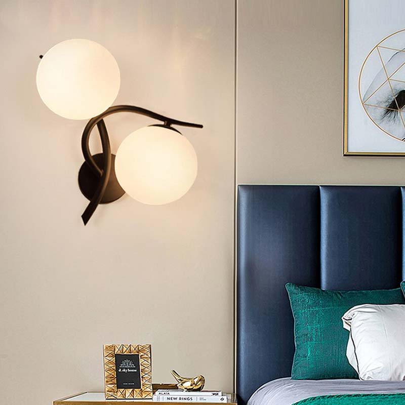 Modern bedroom with a wall sconce, bed, and decorative items.
