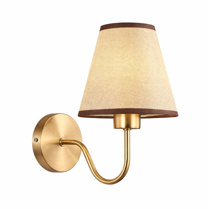 Wall-mounted lamp with gold fixture and beige shade on a white background