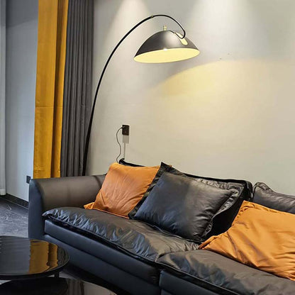 Black Bowl floor lamp with a dome-shaped shade above a modern sofa with cushions.