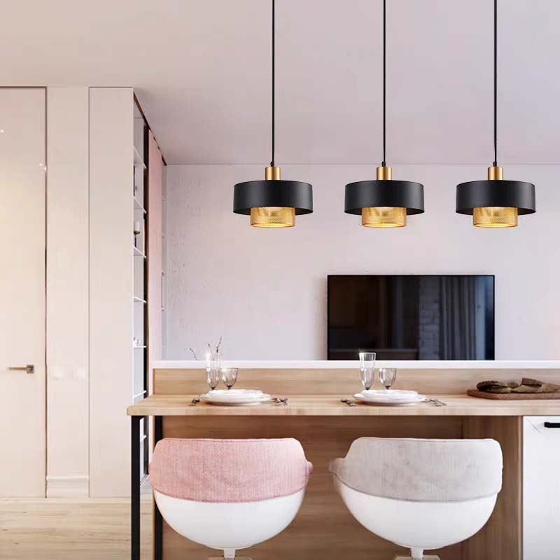Black & Gold Pendant Light with a black outer shade and gold inner diffuser hanging above a kitchen bar counter in a bright modern interior.