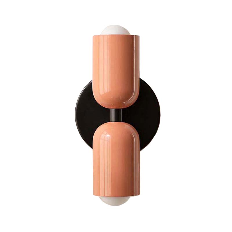 Modern wall sconce with two peach-colored cylindrical shades on a white background