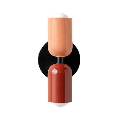 Decorative wall sconce with two cylindrical shades in peach and red on a white background