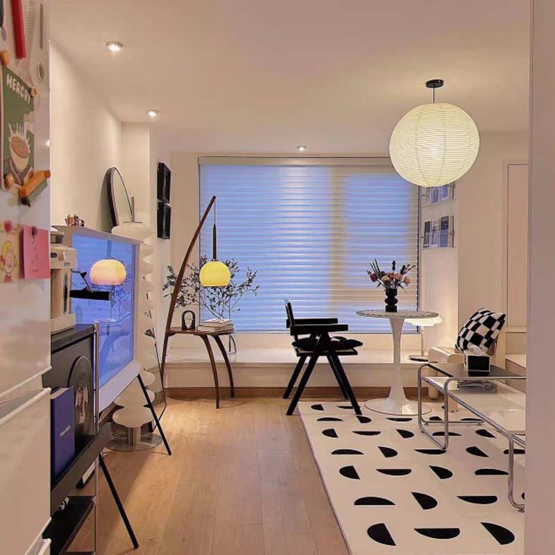 Bright modern living room with minimalist furniture and a large paper ceiling lamp.