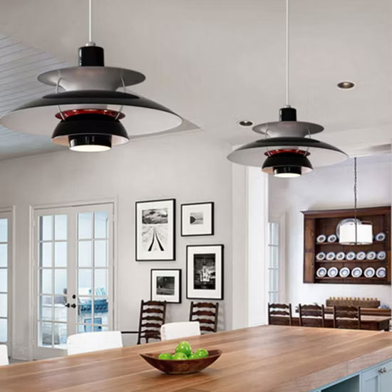 Modern pendant lights hanging in a dining room with wooden table and chairs.