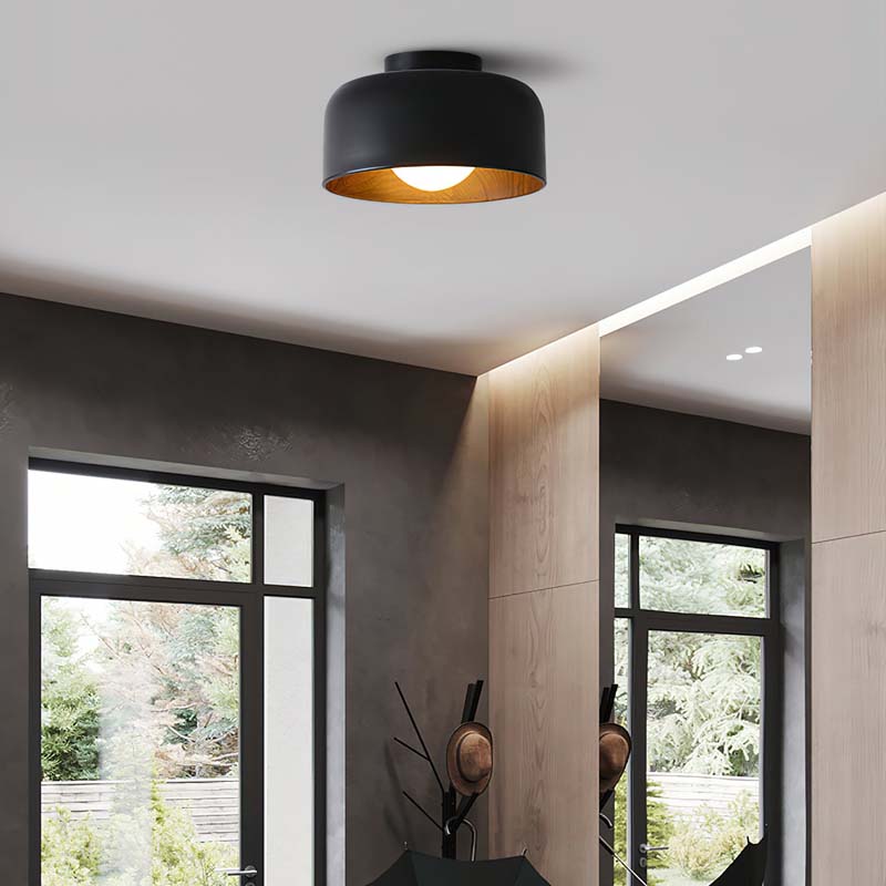 Modern black ceiling light fixture in a room with large windows.