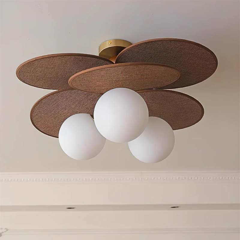 Ceiling light with a raffia lampshade and three spherical glass shades.