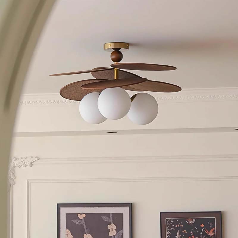 Ceiling light with raffia petals and three white glass globes in an interior setting.
