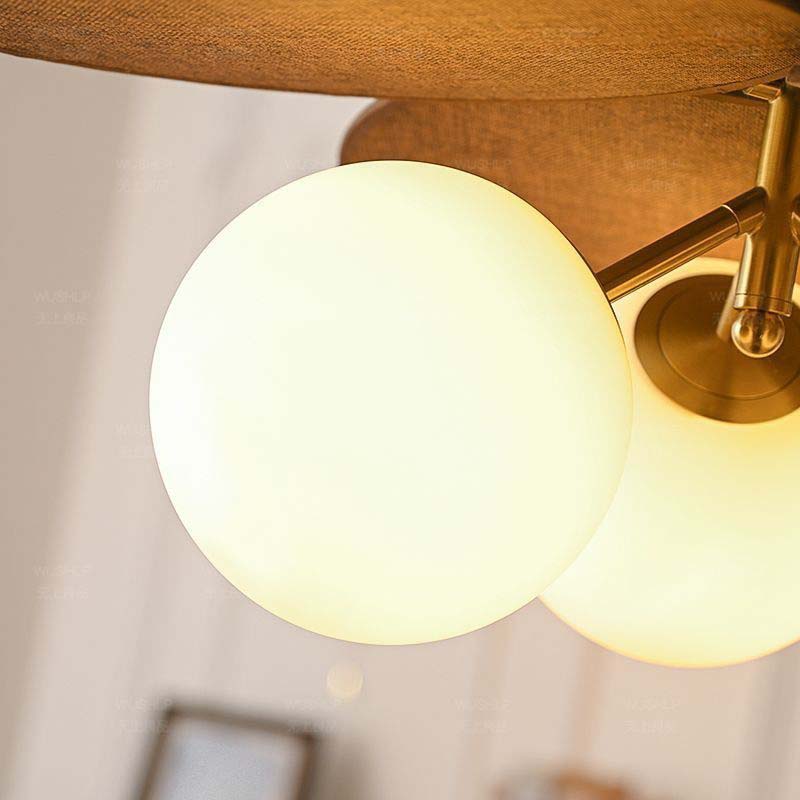 Ceiling light with three spherical glass shades turned on, bottom view.