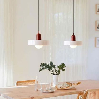 Color Glow Pendant Light in a dining area with a wooden table and a houseplant