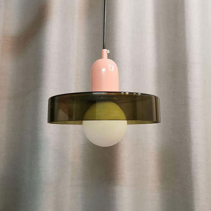 Color Glow Pendant Light with a pink shade and green glass lampshade against neutral curtains.
