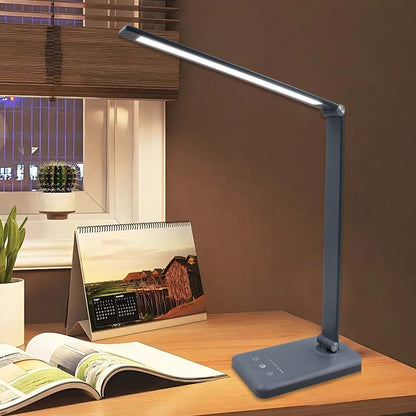 Blue LED desk lamp on a wooden surface with a calendar and magazine in the background.