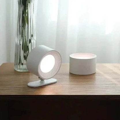 Touch LED Wall Sconce on a wooden table with a vase in the background.
