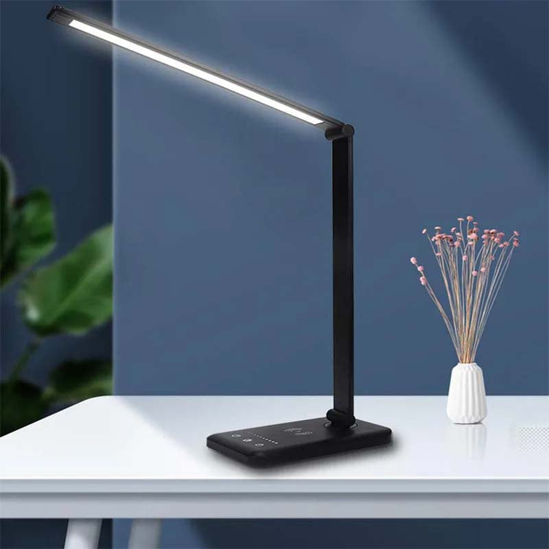 Black LED desk lamp on a white surface with a dark blue background
