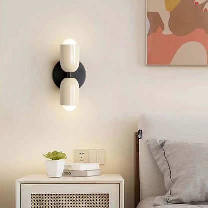 Modern wall sconce on a nightstand next to a bed with abstract art above.