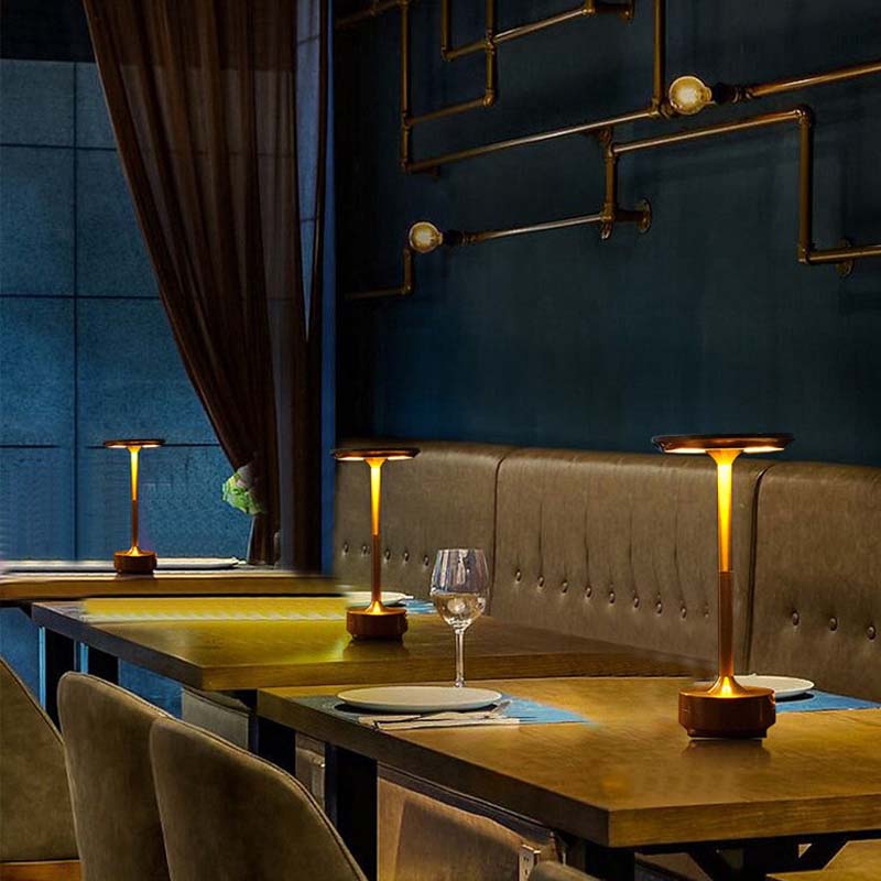 A dining area with wooden tables, chairs and table lamps in a modern restaurant interior.