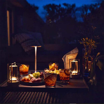 Eclipse Wireless Touch LED Lamp on a table in an outdoor evening setting with drinks and snacks.