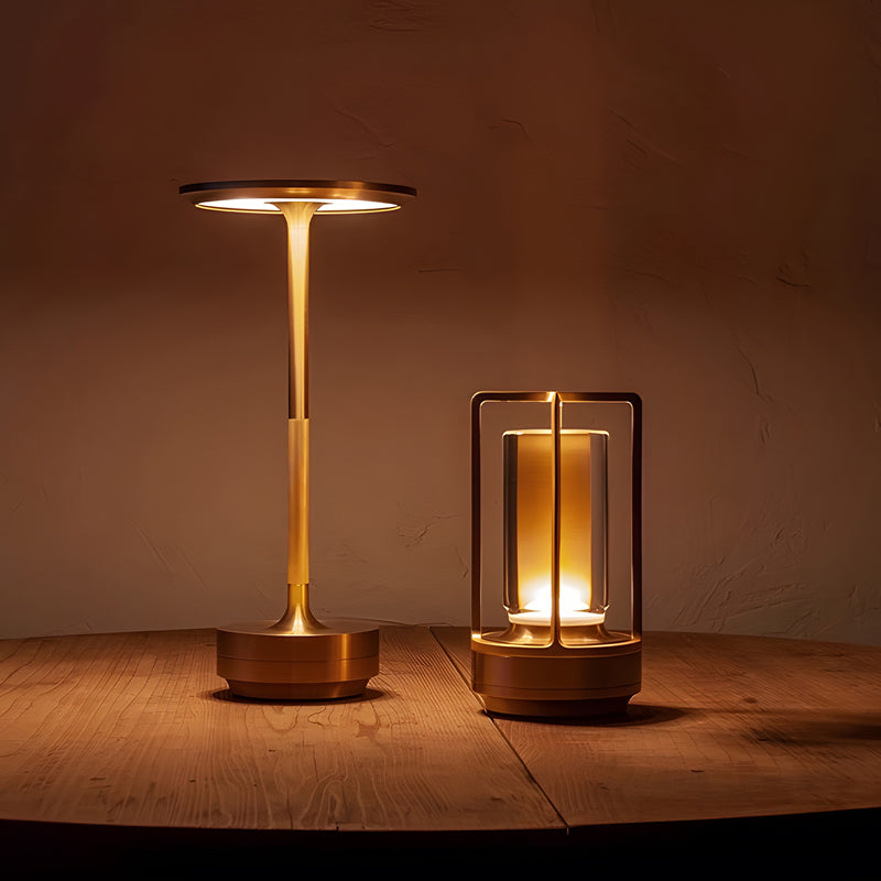 Two gold table lamps on a wooden surface with a warm glow.