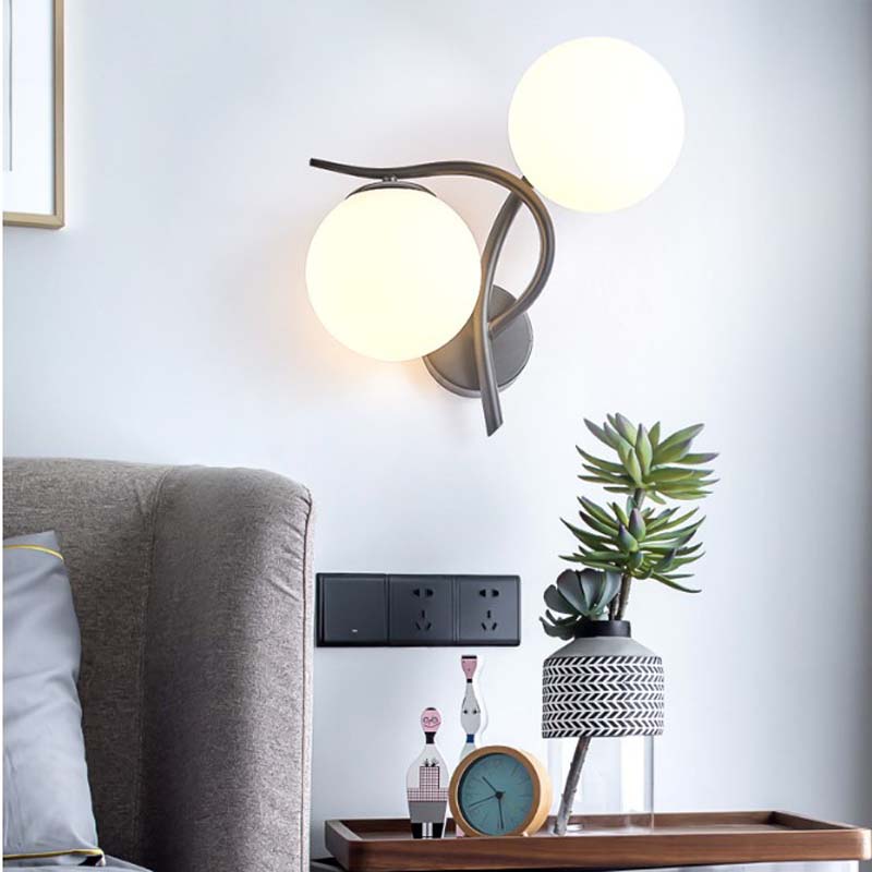 Modern wall lamp with spherical lights in a living room setting.