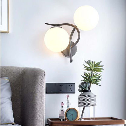 Modern wall lamp with spherical lights in a living room setting.