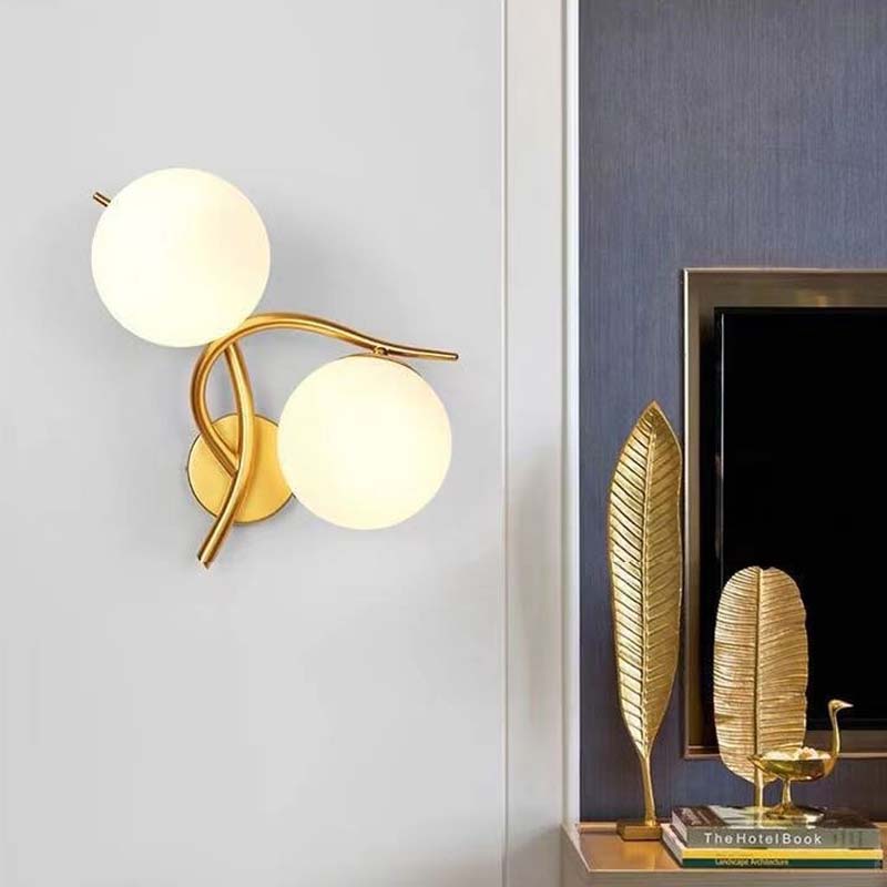 Modern wall sconce with gold and white design on a light gray wall.
