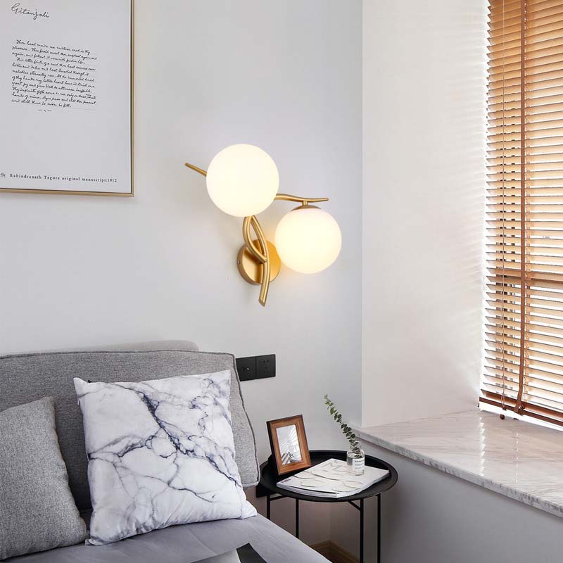 Modern living room with a gray sofa, marble pillow, and wall-mounted lamp.