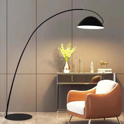 Floor bowl floor lamp with an arched design over an armchair in a modern interior.