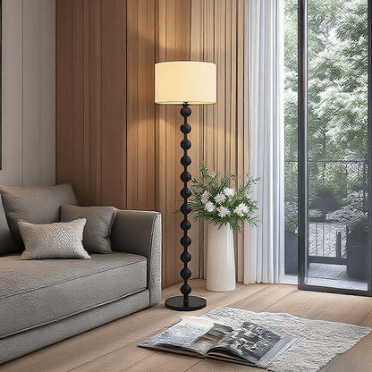 Floor lamp in a modern living room with a grey sofa and an open magazine