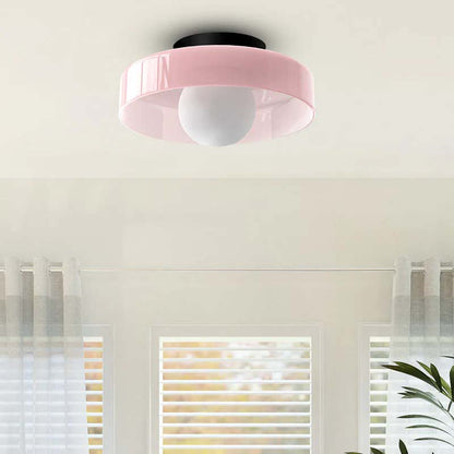 Pink ceiling light fixture on a white ceiling with window blinds in the background