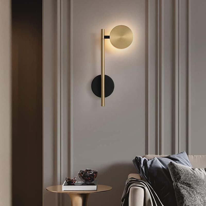 Modern wall sconce on a neutral wall with a side table and sofa in the foreground