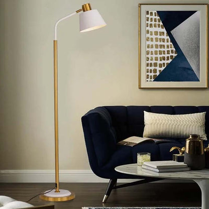Golden floor lamp in a modern living room with a dark blue sofa and an abstract painting on the wall.