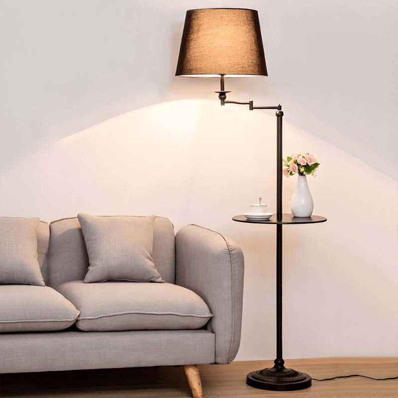 Floor lamp with a reading light next to a sofa in a living room setting.