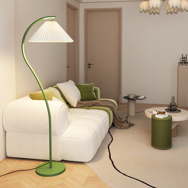 Green floor lamp in a modern living room with white sofa and beige walls.