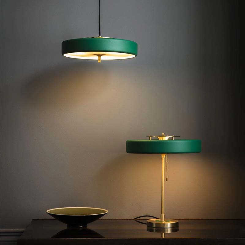 Green minimalist LED pendant light and elegant desk lamp on a dark surface