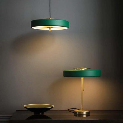 Green minimalist LED pendant light and elegant desk lamp on a dark surface