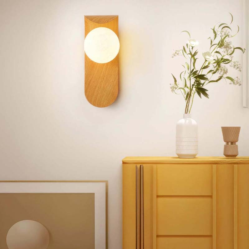 Wall lamp on a white wall with a yellow cabinet and decorative elements.