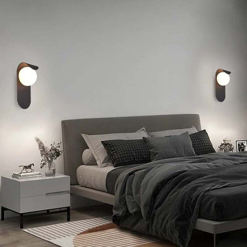Modern bedroom with a bed, nightstands, and wall sconces.