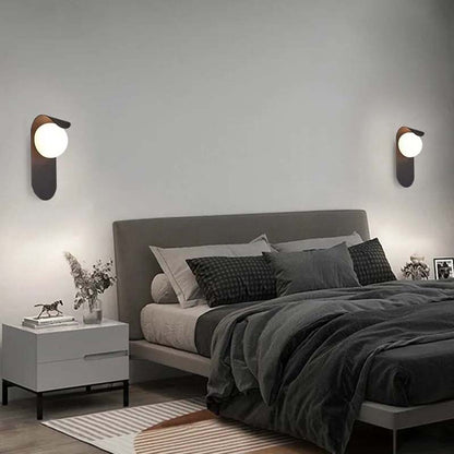 Modern bedroom with a bed, nightstands, and wall sconces.