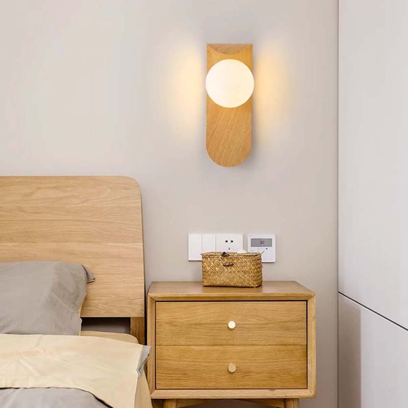 Wooden nightstand with a basket and wall lamp in a bedroom setting