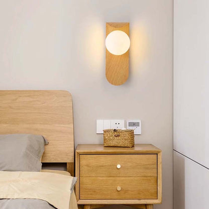 Wooden nightstand with a basket and wall lamp in a bedroom setting