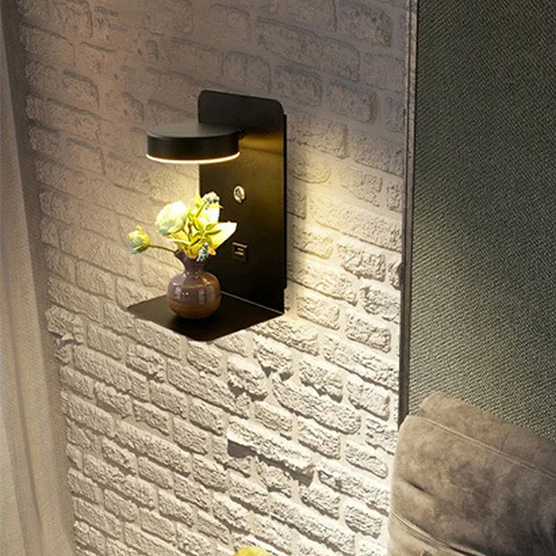 Wall-mounted lamp with a vase of flowers on a brick-patterned wall.