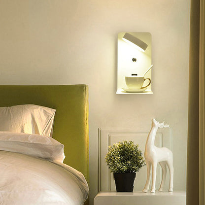 Wall-mounted light fixture with a cup and saucer design in a bedroom setting.