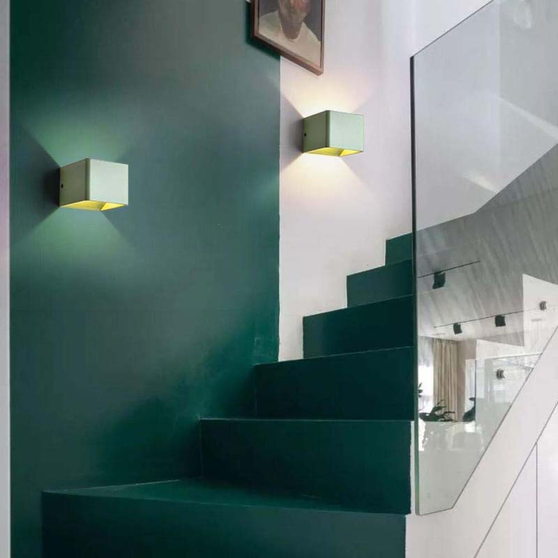Modern staircase with green walls and wall lights in a stylish interior.