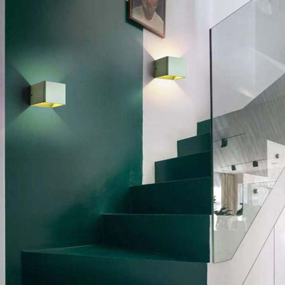 Modern staircase with green walls and wall lights in a stylish interior.