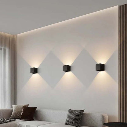 Modern wall lights on a geometrically patterned wall in a living room.