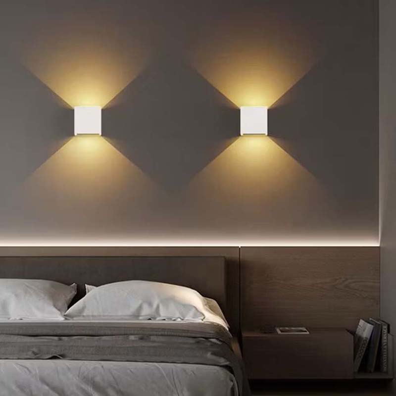 Modern bedroom with wall-mounted lights and a bed.