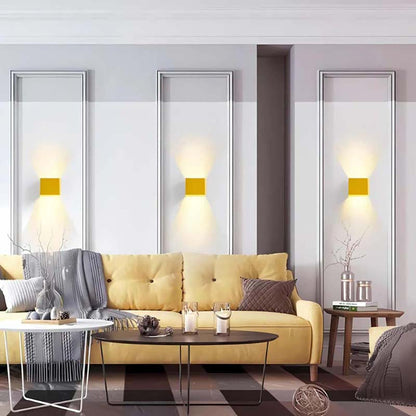 LED Cube Wall Sconce in Modern living room with yellow sofa, coffee table and decorative elements.