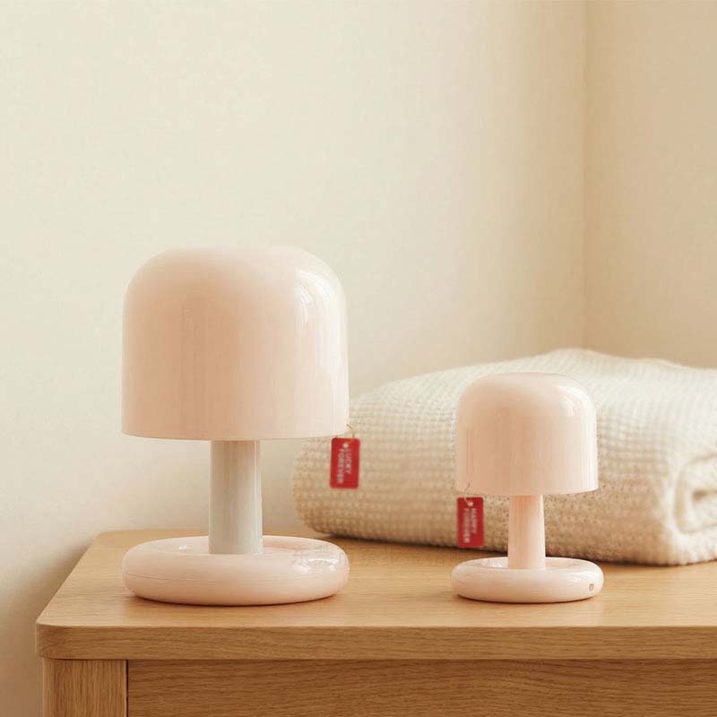 Two small table lamps on a wooden surface with a neutral background