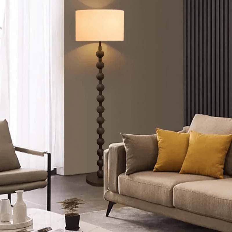 Living room with a beige sofa, yellow pillows, and a floor lamp.
